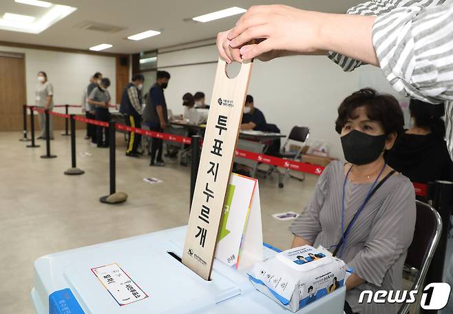 제8회 전국동시지방선거 사전투표 첫날인 27일 오후 대구 달성군 유가읍 행정복지센터에 마련된 사전투표소에서 투표사무원이 투표함에 쌓인 투표용지를 누르기 위해 투표지누르개를 입구에 집어넣고 있다. 2022.5.27/뉴스1 © News1 공정식 기자