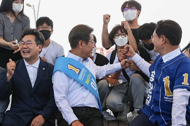 더불어민주당 송영길 서울시장 후보와 이재명 인천 계양을 국회의원 후보가 27일 경기도 김포시 고촌읍 아라 김포여객터미널 아라마린센터 앞 수변광장에서 열린 김포공항 이전 수도권 서부 대개발 정책협약식에서 지나던 학생들과 인사하고 있다. /연합뉴스