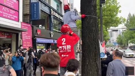 20일 광주 전남대 후문에 걸린 주 후보의 현수막이 훼손되어 다시 걸고 있는 모습.(사진=유튜브)