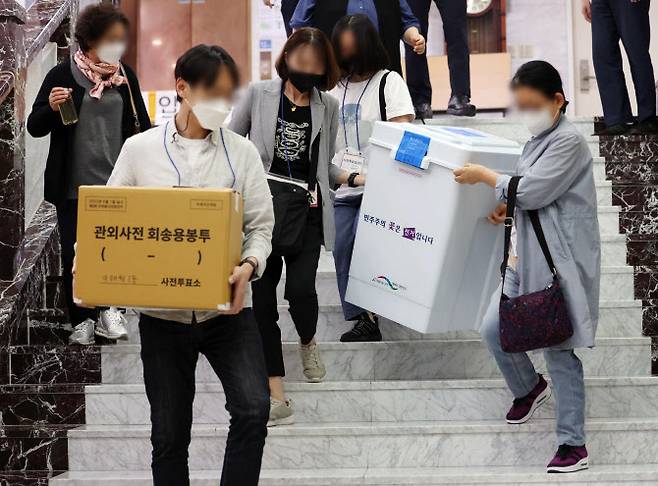 제8회 전국동시지방선거 사전투표 이틀째인 28일 서울 용산구의회에 마련된 사전투표소에서 관계자들이 관내 투표함과 관외사전 회송용봉투를 옮기고 있다. (사진=연합뉴스)