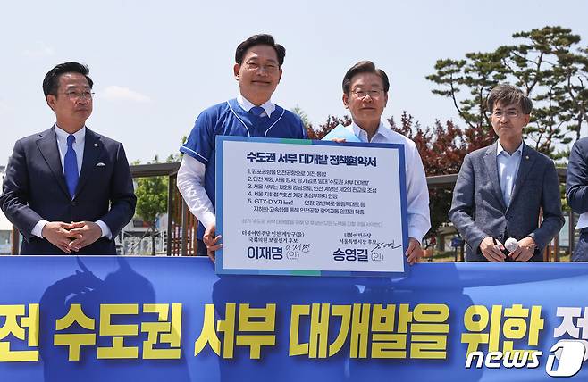 송영길 더불어민주당 서울시장 후보, 이재명 인천 계양을 국회의원 후보가 지난 27일 김포시 고촌읍 아라 김포여객터미널 아라마린센터 앞 수변광장에서 열린 김포공항 이전 수도권 서부 대개발 정책협약 기자회견에서 정책협약서에 서명한 뒤 기념촬영을 하고 있다. 2022.5.27/뉴스1 © News1 국회사진취재단