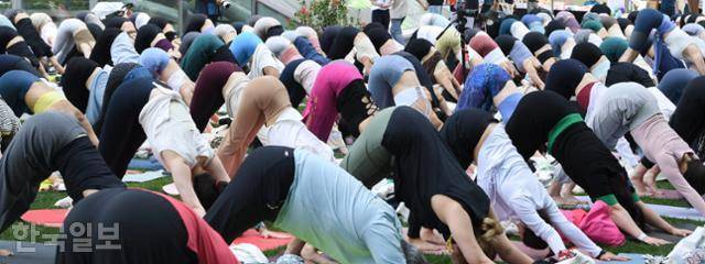 '108 수리야 나마스카라(시퀀스)'는 9동작으로 이뤄져 있는데 우선 바로 선 자세에서 시작, 손끝을 머리 위로 세우고 숨을 내쉬면서 아랫배를 허벅지에 붙이고 이마를 정강이게 가져간다. 다시 아랫배를 잡아당기며 척추를 펴준 뒤 플랭크 자세에서 팔꿈치를 손목 위에 위치시키고 서서히 매트에 몸을 붙인다. 그리고 다시 숨을 마시면서 상체만 들어올리고 내쉬면서 엎드려 뻗쳐 자세인 손바닥과 발 뒷꿈치를 바닥으로 밀어낸다.