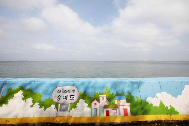 송이도 해안 방파제 그림 넘어로 수평선과 구름이 피어오르는 하늘이 아름답다. ⓒ박준규