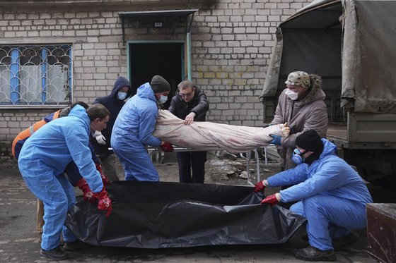 우크라이나 전쟁의 희생자 시신 옮기는 영안실 직원들. AP=연합뉴스