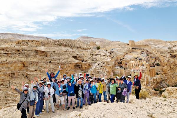 서울 연동교회 권사회원들이 지난 20일 이스라엘 유대 광야 절벽에 있는 마르사바수도원 건너편에서 기념촬영을 하고 있다.