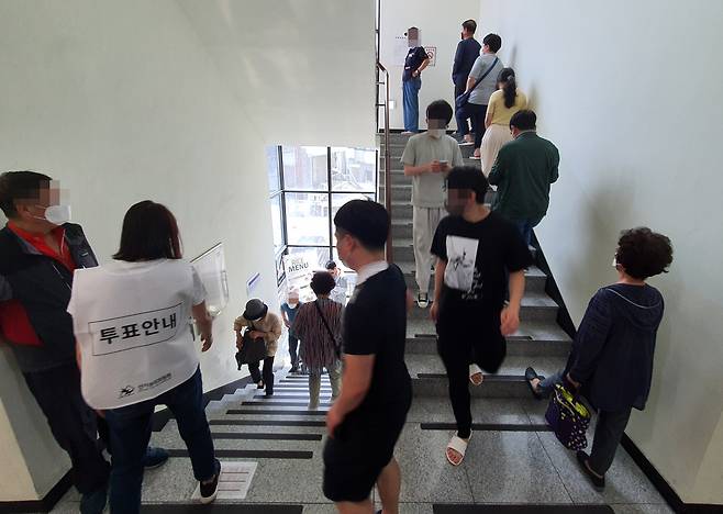 주말인 28일 중랑구 묵1동 사전투표소 계단에서 시민들이 순서를 기다리고 있다. [연합]
