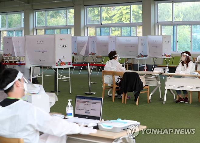 코로나19 확진자 사전투표 (춘천=연합뉴스) 양지웅 기자 = 제8회 전국동시지방선거 사전투표 둘째 날인 28일 오후 강원 춘천시 신사우동 사전투표소가 마련된 춘천북부노인복지관에서 보호복 차림의 투표사무원들이 신종 코로나바이러스 감염증(코로나19) 확진자 투표를 기다리고 있다. 2022.5.28 yangdoo@yna.co.kr