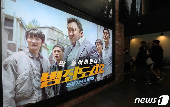 22일 오후 서울 CGV용산에서 영화 '범죄도시2' 포스터 앞으로 시민들이 오가고 있다.  © News1 박세연 기자