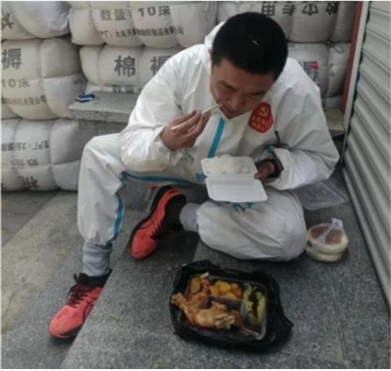 바닥에 앉아서 식사하는 단둥 자원봉사자/ 사진=텐센트 캡처