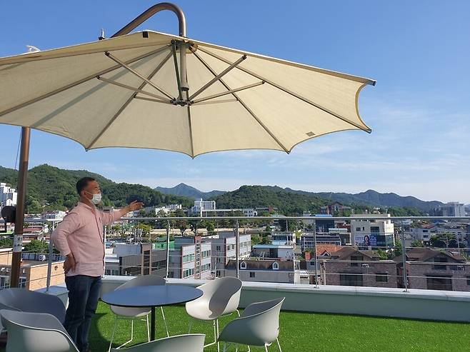 김성국 단장이 전망이 좋은 천사마을카페 옥상에서 포토존 등에 대해 말하고 있다. 박임근 기자