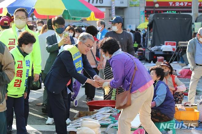 [창원=뉴시스] 홍정명 기자= 박종훈 경남교육감 후보가 29일 오전 창원시 마산회원구 마산역 옆 번개시장을 찾아 시민과 악수하고 있다.(사진=박종훈 선거사무소 제공) 2022.05.29. photo@newsis.com