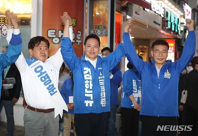 [제주=뉴시스] 우장호 기자 = 김한규(가운데) 더불어민주당 제주시을 국회의원 보궐선거 후보가 29일 오후 제주시청 인근 거리에서 총력유세를 열어 오영훈(왼쪽) 같은 당 제주도지사 후보·문대림 전 제주국제자유도시개발센터 이사장과 손을 들어 인사하고 있다. 2022.05.29. woo1223@newsis.com