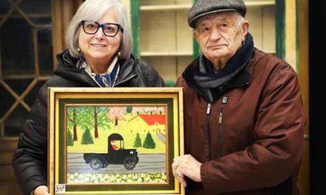 아이린(왼쪽)·토니 데마스 부부가 최근 경매에 출품해 27만2548달러(약 3억4000만원)에 낙찰된 모드 루이스의 그림 검정 트럭을 들어 보이고 있다. 밀러&밀러 옥션 페이스북 캡처