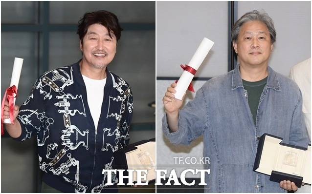 제 75회 칸영화제 시상식에서 남우주연상을 수상한 배우 송강호(왼쪽)와 감독상을 수상한 박찬욱 감독이 30일 오후 인천국제공항을 통해 귀국해 트로피를 들어보이고 있다. /인천국제공항=이새롬 기자