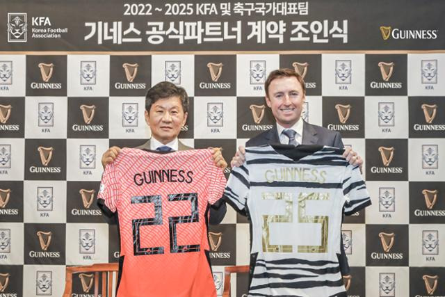 정몽규(왼쪽) 대한축구협회 회장과 댄 해밀턴 디아지오코리아 대표가 30일 경기 파주NFC에서 대한축구협회 및 축구 국가대표팀과 기네스 공식 파트너 계약 조인식을 진행한 뒤 유니폼을 들어보이고 있다. 디아지오코리아 제공