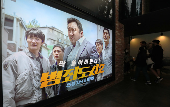 지난 22일 오후 서울 CGV용산에서 영화 '범죄도시2' 포스터 앞으로 시민들이 오가고 있다. /사진제공=뉴스1