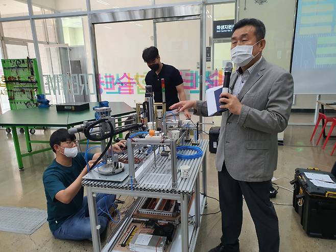 강구홍 폴리텍대학 광주캠퍼스 학장이 27일 본관 1층 창의융합기술센터에서 실습하는 학생들의 제품에 대해 설명하고 있다. [김용훈 기자]