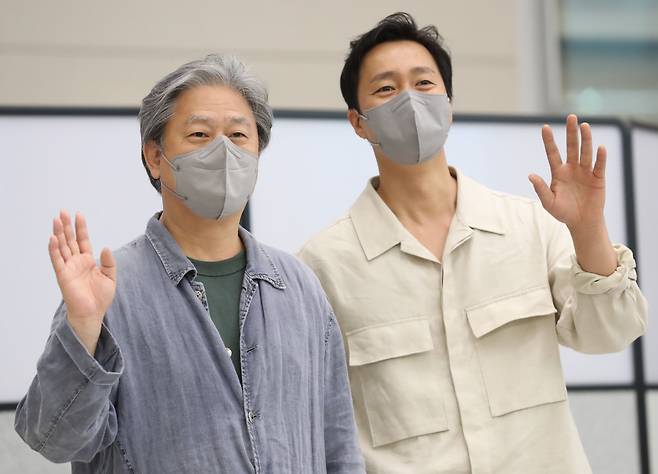 제75회 칸국제영화제에서 감독상을 받은 박찬욱 감독이 배우 박해일과 함께 30일 오후 인천국제공항 제2여객터미널을 통해 귀국, 취재진을 향해 인사하고 있다. [연합]