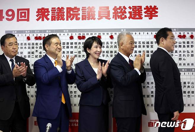 기시다 후미오 일본 총리가 31일(현지시간) 도쿄 자민당 당사에서 중의원 선거서 당선된 의원 이름에 장미 모양 리본을 달며 포즈를 취하고 있다. © AFP=뉴스1 © News1 우동명 기자