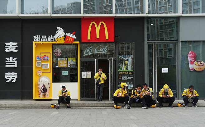 중국 베이징의 맥도날드 매장 앞에 배달 플랫폼 메이퇀 소속 배송 기사들이 앉아 있다. /김남희 특파원