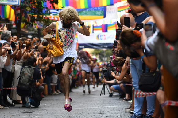 4일(현지시간) 스페인 마드리드 성소수자(LGBT) 커뮤니티에 인기 있는 지역인 추에카(Chueca)에서 ‘프라이드 하이힐 신고 달리기’가 열려 참가자가 힐을 신고 달리고 있다.AFP 연합뉴스