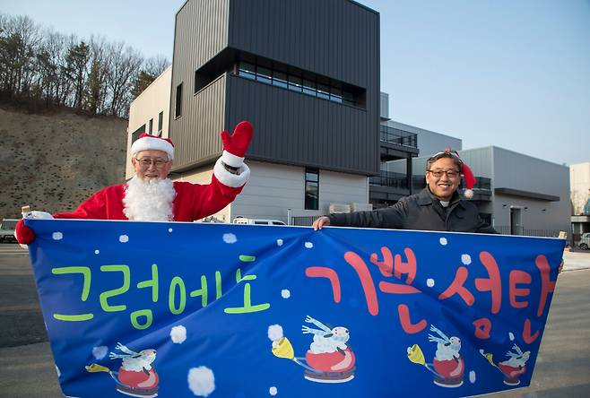 발달장애인 시설인 강화 우리마을은 2019년 가을 화재로 콩나물 공장이 전소됐지만 1년만에 십시일반 도움으로 훨씬 멋진 공장을 다시 지었다. 2020년 성탄을 앞두고 완공된 공장 건물 앞에서 김성수 주교(왼쪽)와 이대성 당시 원장 신부가 손을 흔들고 있다. /박상훈 기자