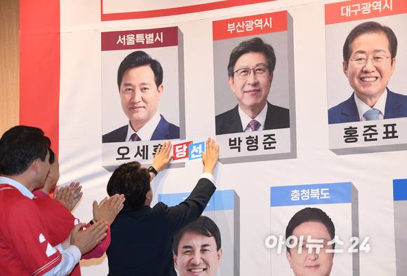 이준석 국민의힘 대표를 비롯한 지도부가 2일 서울 국회도서관 대회의실에 차려진 제8회 전국동시지방선거 개표상황실에서 당선자 사진에 스티커를 붙히고 있다. [사진=국회사진취재단]