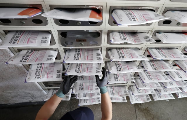 서울 강서구의 한 아파트에서 집배원이 투표안내문 및 선거공보물을 우편함에 넣는 모습. / 사진=연합뉴스