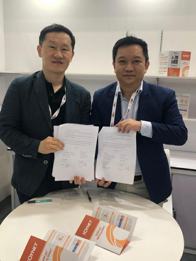 박정우 소이넷 대표(왼쪽)가 1일 싱가포르에서 개막한'커뮤닉 아시아 2022'에서 자사 부스를 방문한 현지 기업과 협력을 약속한 문서를 들어보이고 있다.