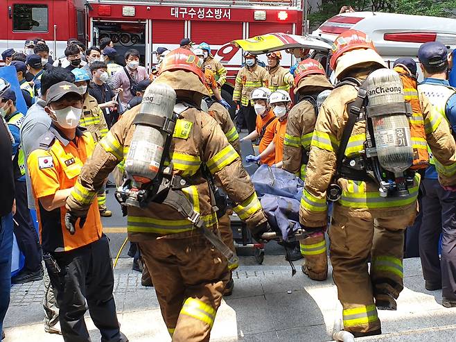 9일 오전 10시55분쯤 대구 수성구 범어동 대구지법 인근에 있는 7층 건물에서 원인을 알 수 없는 불이 났다, 신고를 받고 출동한 119대원들이 입주자들을 이송하고 있다. 소방당국은 이날 사고로 7명이 숨진 것으로 추정했다.(대구소방본부제공)2022.6.9/뉴스1