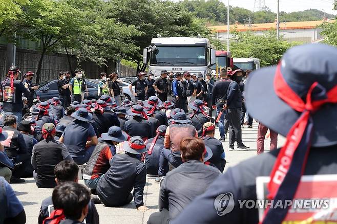 트레일러 막아선 화물연대 (포항=연합뉴스) 손대성 기자 = 지난 10일 경북 포항시 남구 포항철강산업단지 내 한 철강업체 입구에서 화물연대 포항지역본부 조합원 200여명이 회사에 들어가려는 트레일러를 막아서고 있다. 경찰이 출동한 가운데 화물연대는 30여 분간 승강이를 벌이다가 통행로를 열었다. 2022.6.10 sds123@yna.co.kr