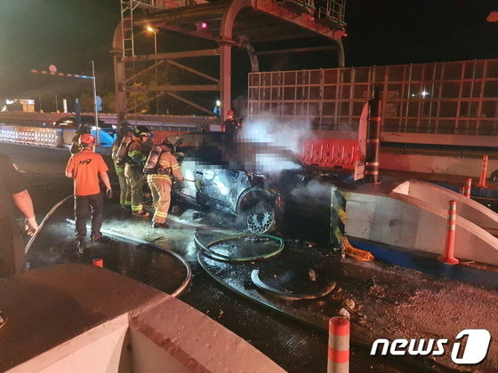 4일 오후11시쯤 남해고속도로를 달리던 전기차에 불이 나 119구조대원이 불을 끄고 있다(부산경찰청 제공)(C) 뉴스1