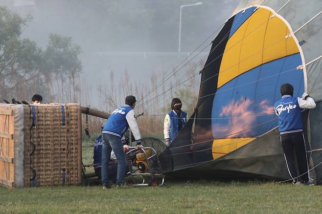 선풍기로 열기구 풍선 안에 공기를 채운 뒤 버너로 온도를 높이고 있다. [사진/진성철 기자]
