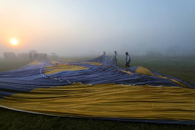 직원들이 열기구 풍선을 펼치며 손상된 곳이 없는지 점검하고 있다 [사진/진성철 기자]