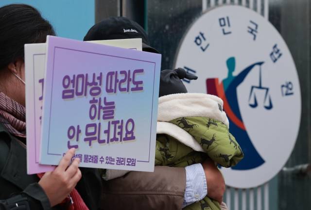 성본변경 청구인 가족이 서울가정법원 앞에서 열린 ‘엄마의 성·본 쓰기’ 성본변경청구 허가 결정을 환영하는 기자회견에 아이를 안고 있다. 연합뉴스