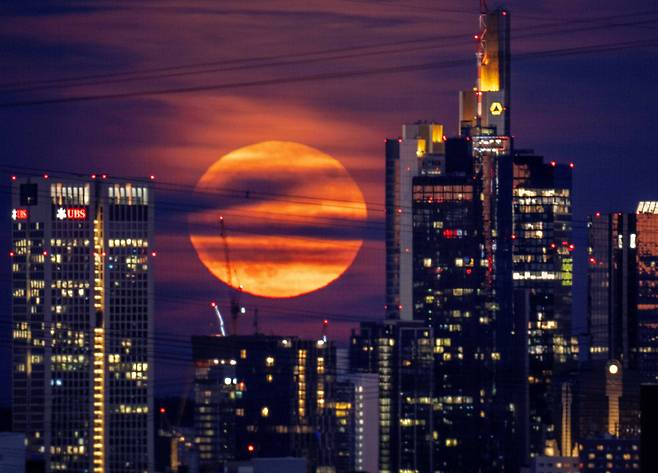 14일(현지 시각) 밤 독일 프랑크푸르트 은행가의 건물 뒤로 보름달이 떠오르고 있다 / AP 연합뉴스