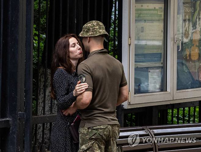 전쟁이 갈라놓는 사랑 그리고 사람 (키이우=연합뉴스) 황광모 기자 = 17일(현지시간) 우크라이나 수도 키이우 중심에서 군복을 입은 연인과 헤어져야 하는 한 여성이 아쉬운 눈빛으로 얼굴을 바라보고 있다. 2022.6.17 hkmpooh@yna.co.kr