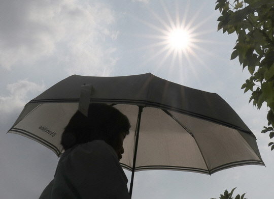 1년 중 낮 길이가 가장 길다는 절기상 하지(夏至)를 하루 앞둔 20일 대전 유성구 일대에서 한 시민이 뜨거운 태양 아래 양산을 쓴 채 이동하고 있다. 최은성 기자