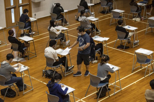 홍콩의 한 중등학교에서 시험 감독관이 대학입학시험(HKDSE)을 치르는 수험생들에게 시험지를 나눠주고 있다. AP/뉴시스