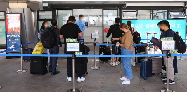 지난달 26일 인천국제공항 제1터미널 PCR 검사 센터 앞에서 입국자들이 검사를 기다리고 있다. 정부는 원숭이두창 발생 국가 방문 입국객을 대상으로 발열체크 및 건강상태 질문서도 받고 있다. 연합뉴스.