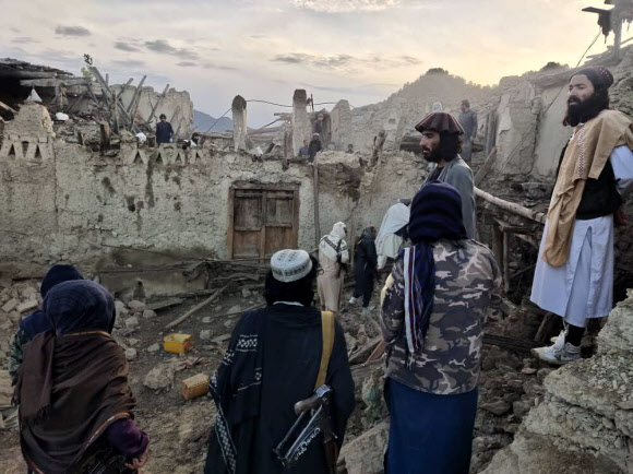 아프가니스탄 사람들이 22일 새벽 동부 팍티카 지방을 덮친 규모 6.1의 지진 때문에 무너진 주택 더미를 바라보며 망연자실하고 있다.박타르 통신 제공 AP 연합뉴스