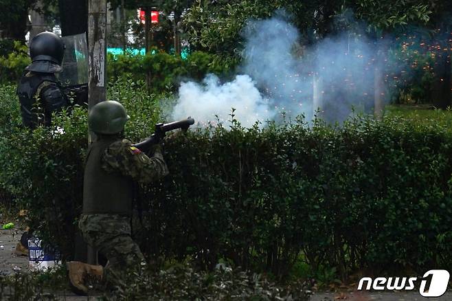 22일(현지시간) 에콰도르 키토에서 군인이 기름값 인상에 항의하는 시위대를 향해 최루 가스를 발사하고 있다. © AFP=뉴스1 © News1 우동명 기자
