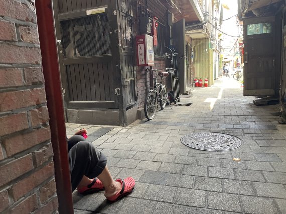지난 21일 오후 서울 돈의동 쪽방촌에서 주민 70대 이모씨가 집 앞 응달에 앉아 더위를 식히고 있다 /사진=박지연 기자