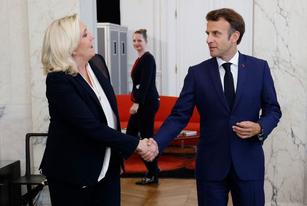 에마뉘엘 마크롱 프랑스 대통령(오른쪽)이 21일(현지시간) 파리 엘리제 궁에서 극우 성향의 마린 르펜 국민연합 대표와 악수를 하고 있다.  /AFPBBNews=뉴스1