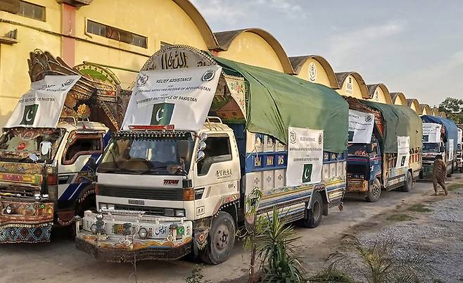 23일(현지시간) 파키스탄 이슬라마바드의 한 창고에서 아프가니스탄 지진 피해 지역에 제공할 텐트, 담요, 응급 의약품 등 구호 물품을 실은 트럭들이 아프간으로 떠날 채비를 하고 있다.   이슬라마바드=AP/뉴시스