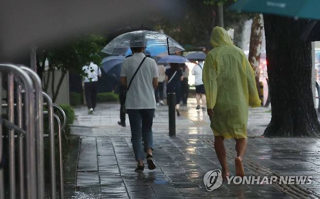 '맨발의 퇴근' (서울=연합뉴스) 김인철 기자 = 장맛비가 내리는 23일 오후 서울 서대문구 미근동 거리에서 우비를 입은 한 시민이 맨발로 길을 걷고 있다. 2022.6.23 yatoya@yna.co.kr