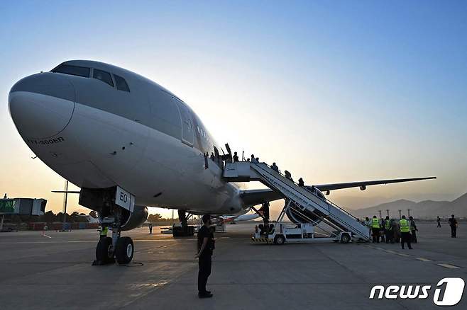 미국인 등 승객 200명이 9일(현지시간) 아프가니스탄 카불 공항에서 카타르 항공 소속 여객기에 오르고 있다. 지난달 30일 밤 11시59분 마지막 미 군 수송기가 떠난 이후 첫 탈출 비행이다. © AFP=뉴스1