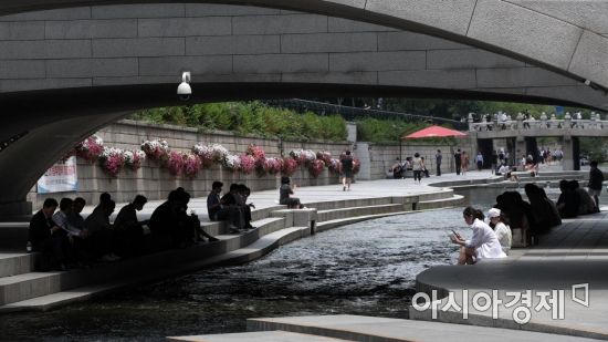 서울 낮 최고 기온이 30도까지 오르며 무더운 날씨를 보인 22일 시민들이 서울 청계천에서 더위를 식히고 있다./김현민 기자 kimhyun81@