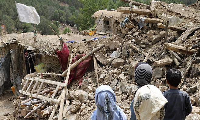 지난 22일(현지시간) 아프가니스탄 동부 호스트주(州) 스페라 지역의 어린이들이 강진으로 파괴된 주택 앞에 서 있다. AP연합뉴스