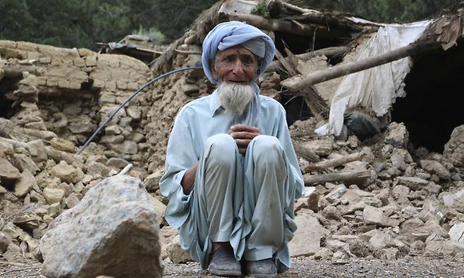 지난 22일(현지시간) 아프가니스탄 호스트주 스페라 마을에서 한 노인이 지진으로 파괴된 집 주변에 앉아 있다. AP뉴시스